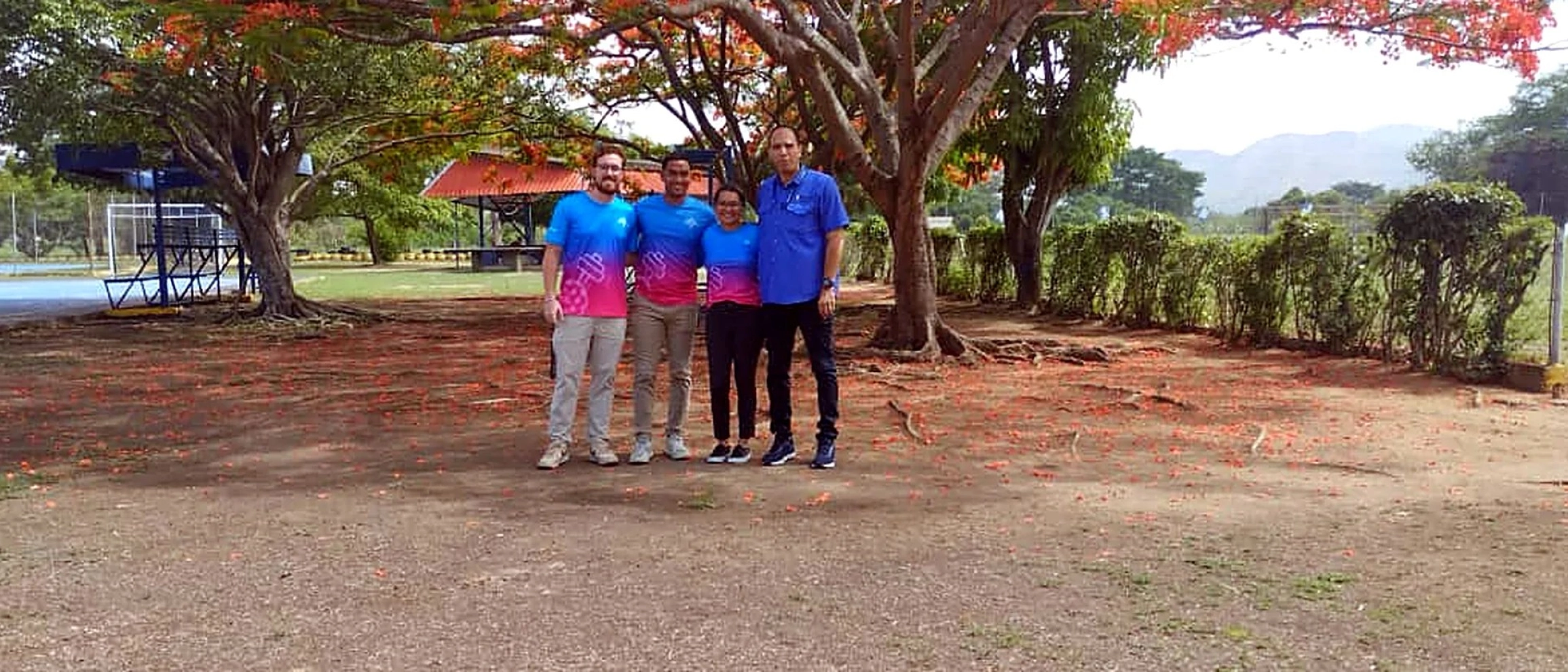 Vista panorámica del grupo bajo el árbol con flores rojas